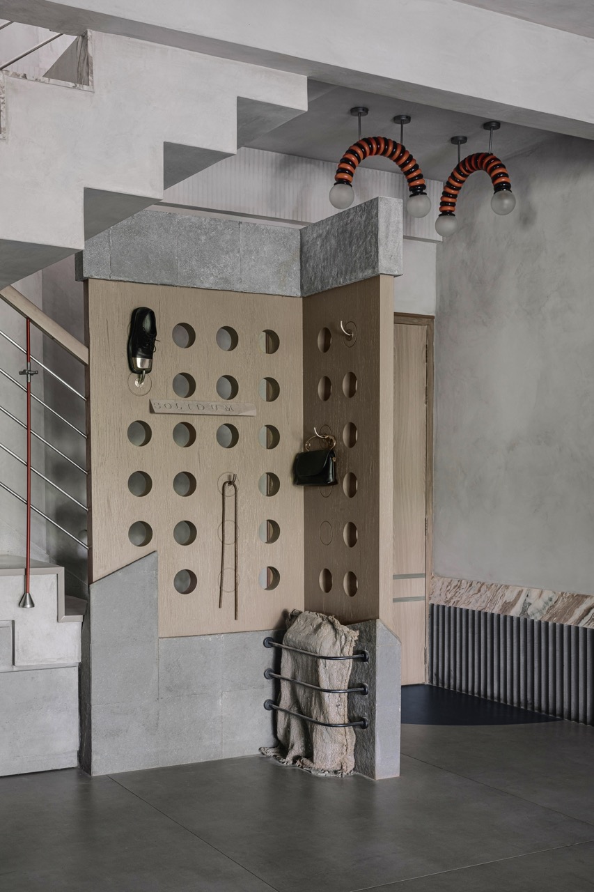 In the entryway, Smita opts for a soft, utilitarian partition in the form of a wood-and-stone screen instead of a conventional foyer