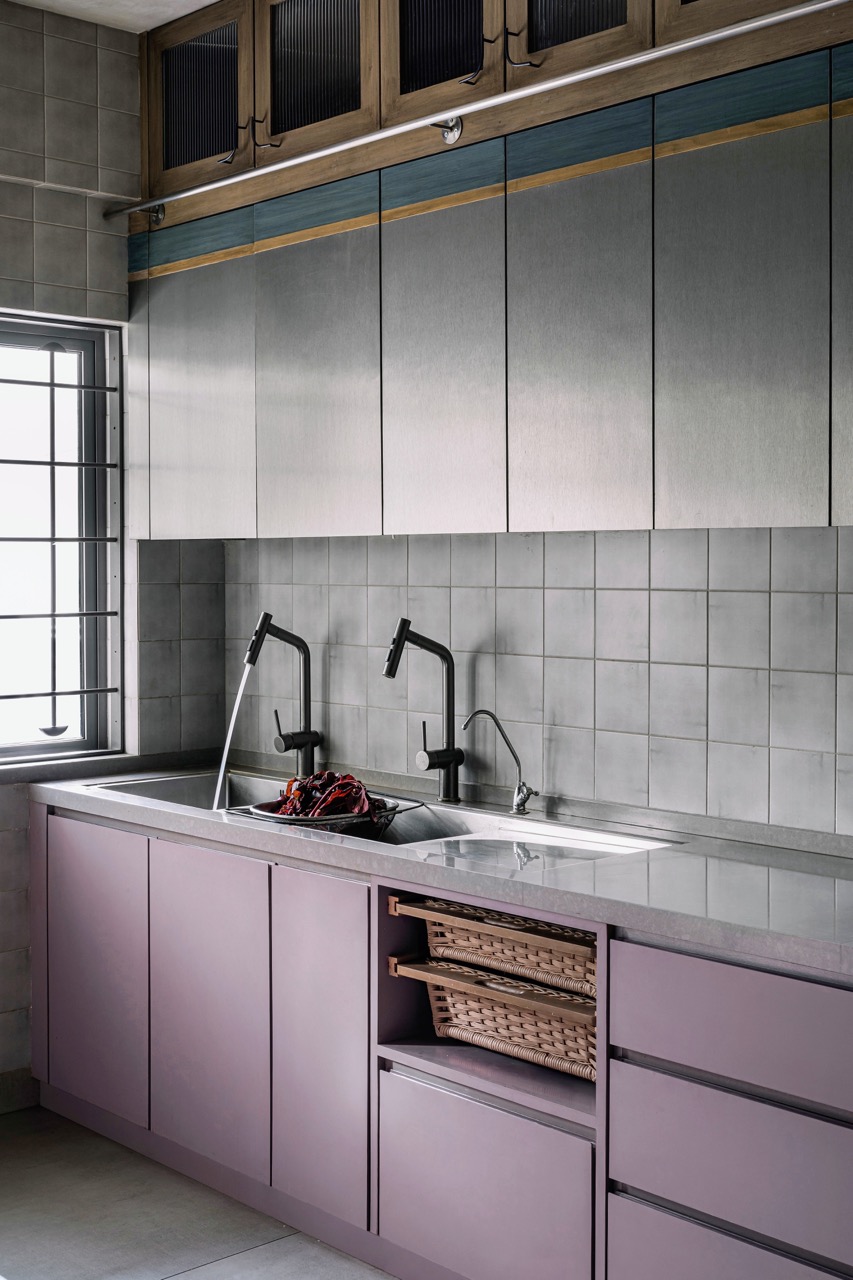 The kitchen features lower shutters in deep mauve to contrast with the upper ones in steel laminate and deep blue stained veneer. The loft shutters are solid wood, with fluted glass and curved steel handles