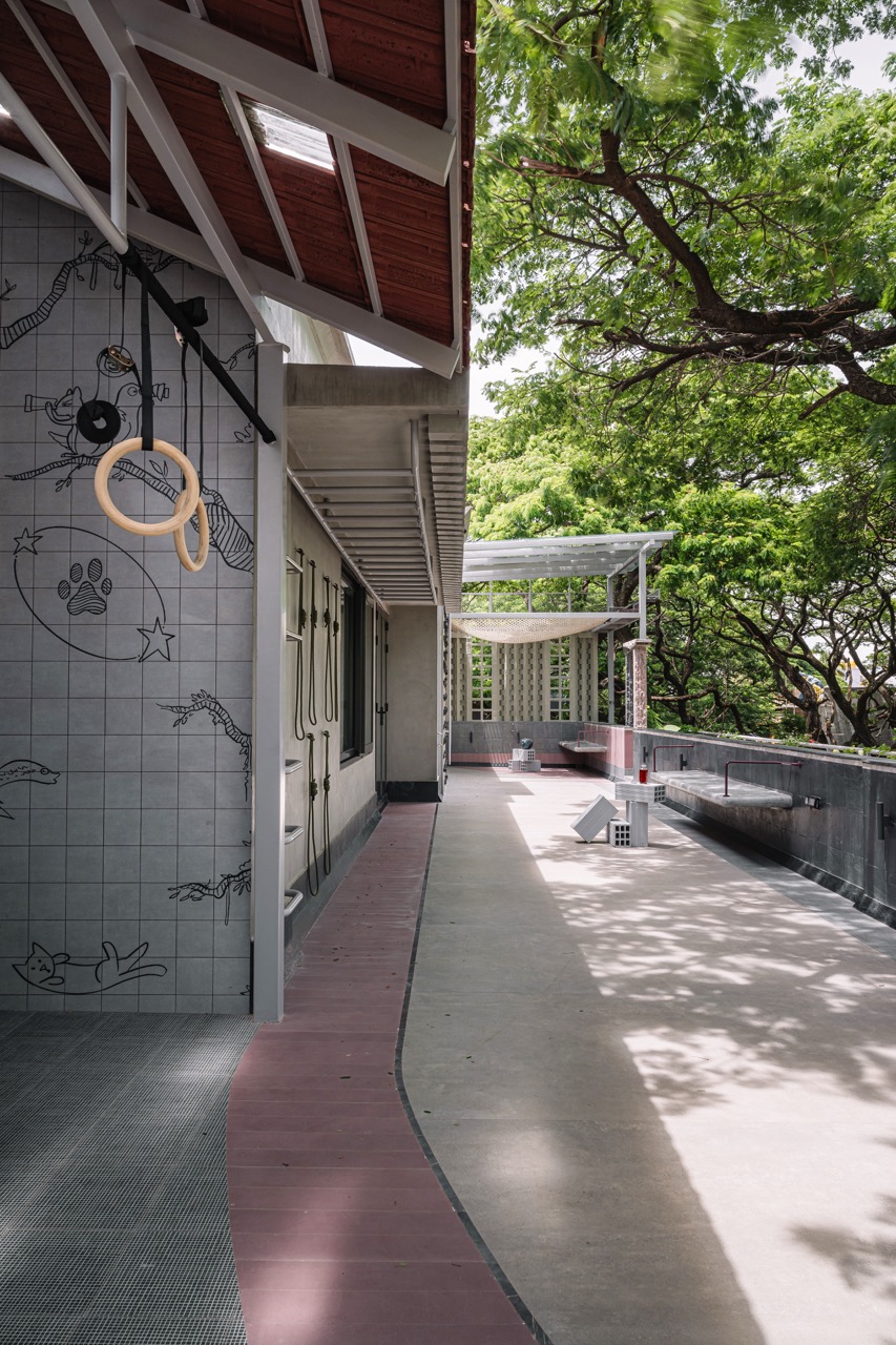 The outdoor terrace is a zone for relaxation as well as a gym with carefully considered flooring punctuated by a ribbon of pink tiles and a grey-tiled wall brought to life by graffiti-style illustrations of impish critters