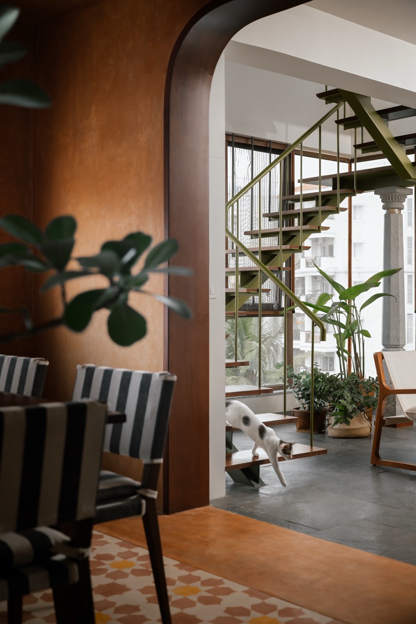 The custom staircase pairs a carved stone column from ANM Gallery, Karaikudi, with metal and wooden treads, bringing traditional craft into a modern setting