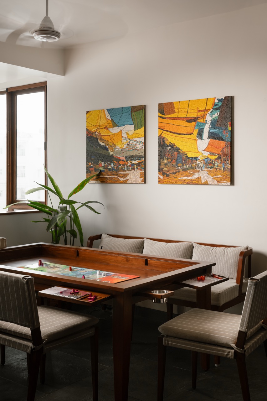 The family lounge offers a relaxed space for reading or board games, with a custom table and game bench by ma+rs, chairs by Josmo Studio, and artwork by Prashant Kulkarni