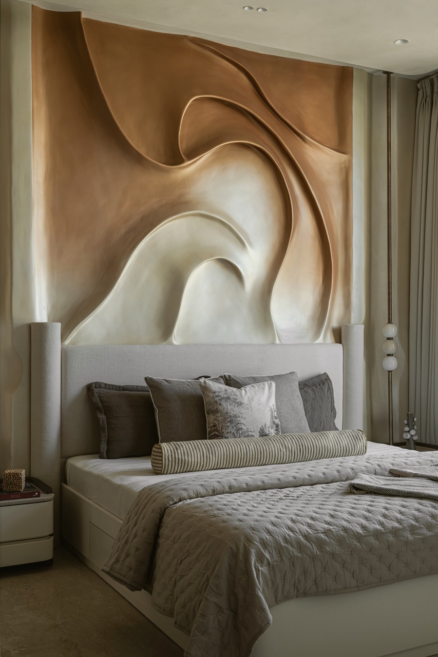In the bedrooms, the walls take centre stage. In the master suite, copper-toned ombré folds sweep across the surface, appearing almost three-dimensional and creating a striking sculptural moment