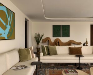 In the refined, earth-toned living room, a wall-mounted sculptural cane seat by The Wicker story makes a dynamic architectural statement