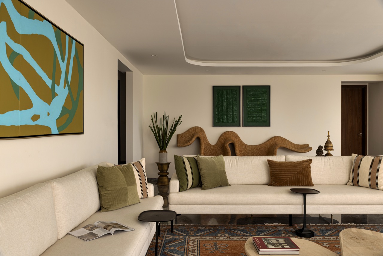 In the refined, earth-toned living room, a wall-mounted sculptural cane seat by The Wicker story makes a dynamic architectural statement