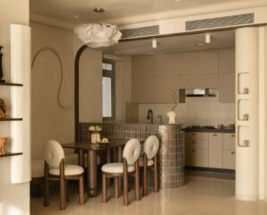 The open-plan layout furthers Rohini’s agenda for free-flowing spaces with the dining and kitchen areas separated by a curved kitchen island clad in metallic tiles. The wave motif makes a subtle appearance on the dining room wall. The table, chairs, and bench are by Anthem Home