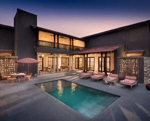 A private courtyard pool anchors the kothi at Aramness Gir, with stone walls, shaded verandahs, and jali panels