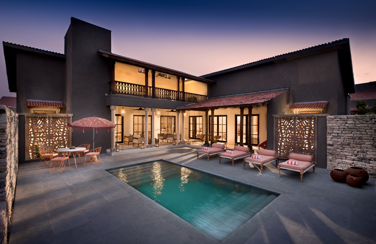A private courtyard pool anchors the kothi at Aramness Gir, with stone walls, shaded verandahs, and jali panels
