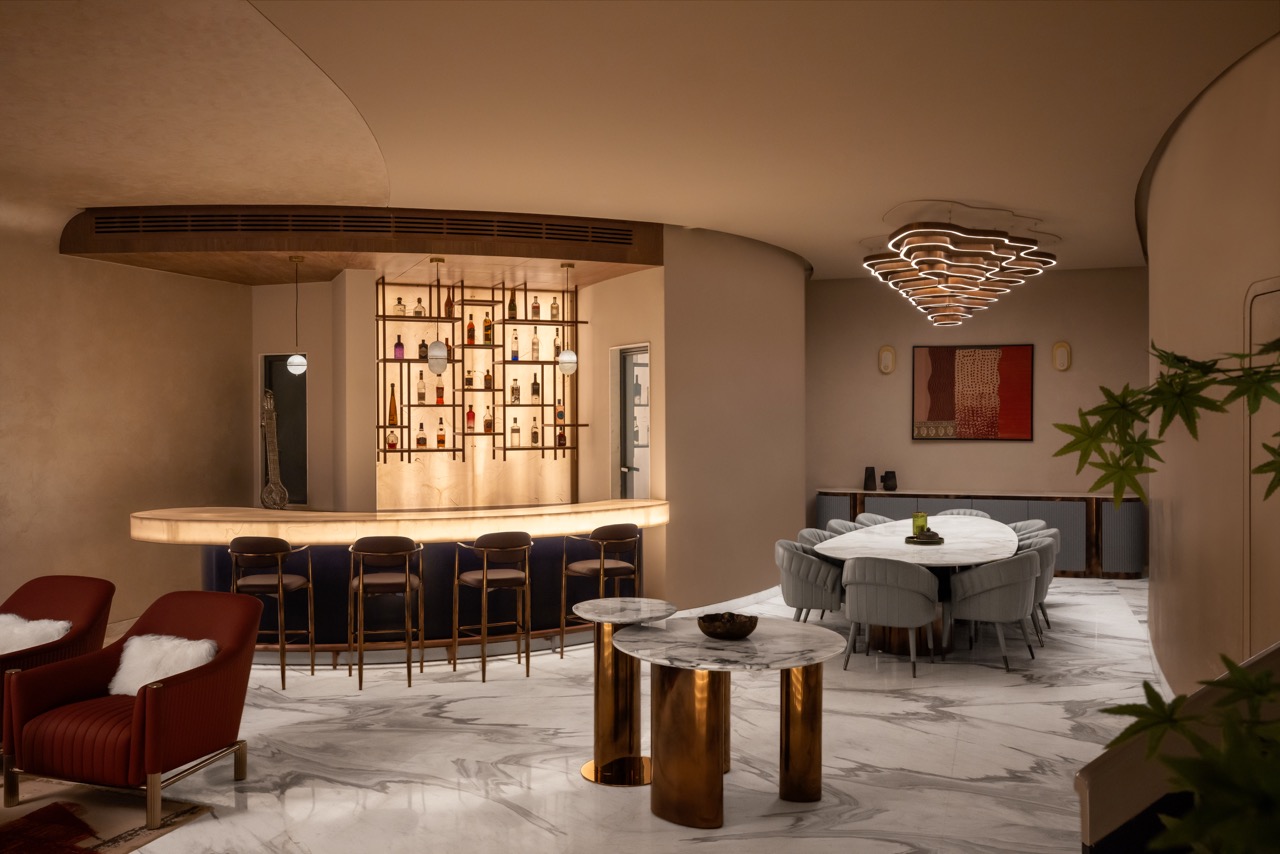 Planned as a hosting zone, the basement balances open seating with a sculptural bar counter