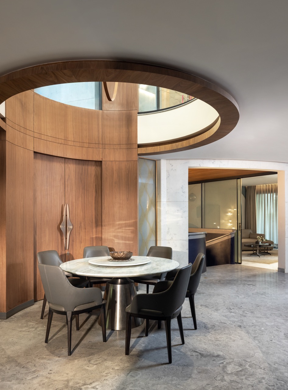 The dining area sits at the centre of the home, placed beneath a circular opening that lets in natural light