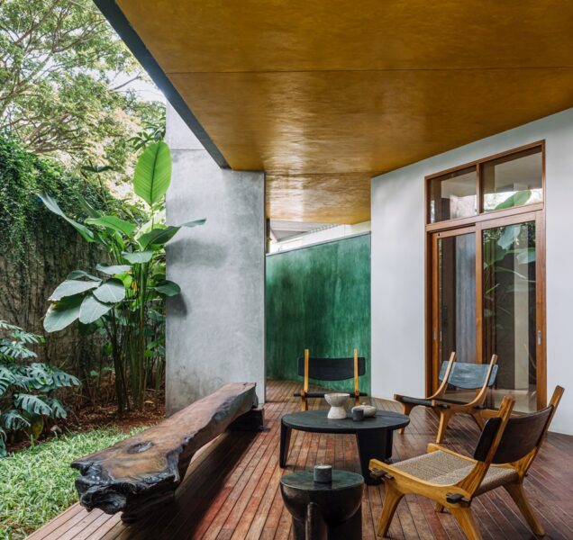 The deck opens to a green patch, with furniture by Kayu and wood flooring that blends into the landscape. The ochre ceiling and green corrugated wall at the far end complements the earthy nature of the space