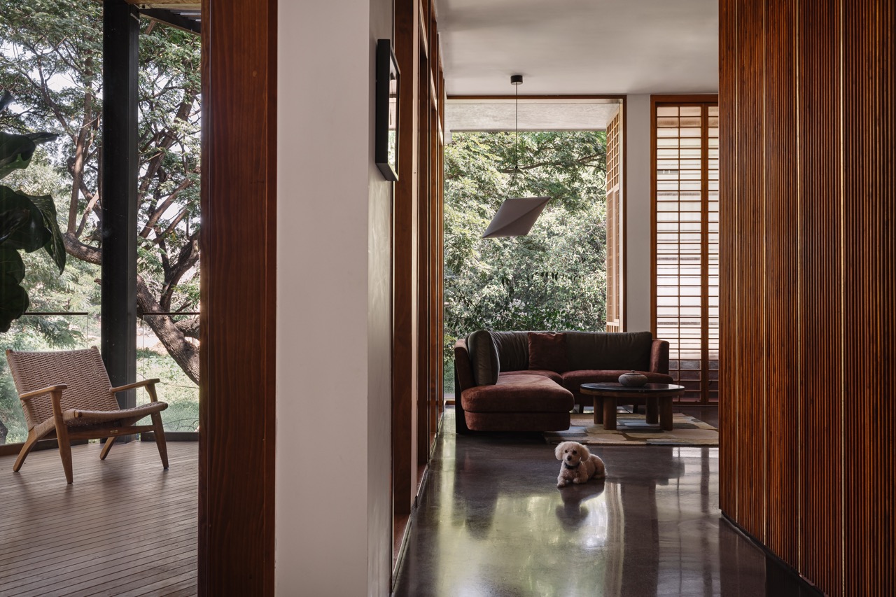A view toward the family room, with a glimpse of the living room verandah beyond. Concrete flooring by AAD and Living Elements and furniture by Kayu and Timberworks India by Virasp Bativala define the space