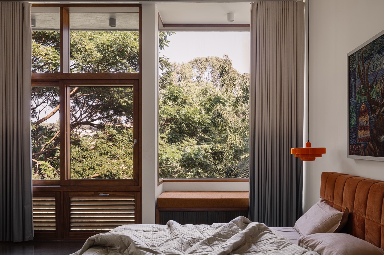 The kids’ bedroom looks out onto a canopy of trees, with a bay window offering a quiet place to sit and take in the view