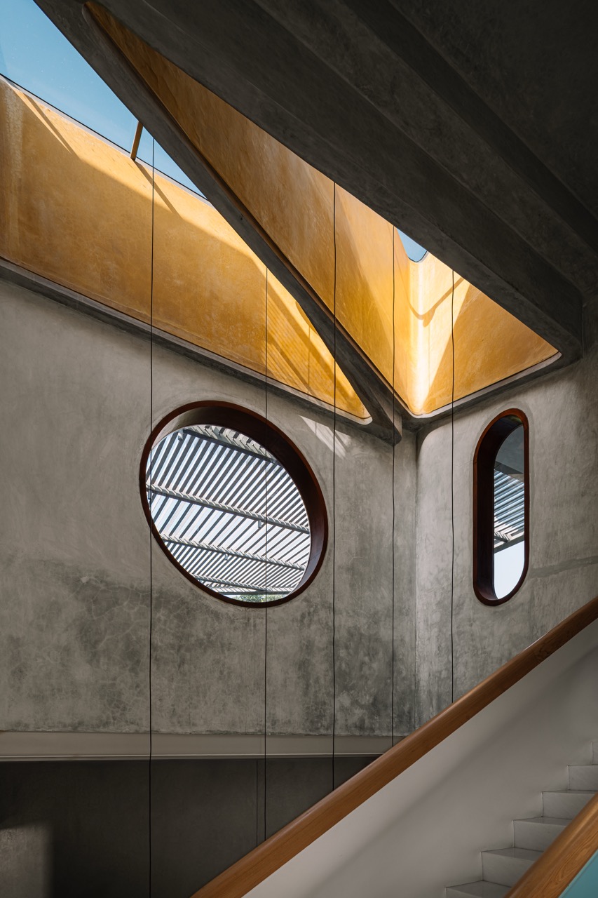 The skylight above the atrium is formed by intersecting triangles, echoing the site and building geometry, with circular cut-outs framing the pergola above