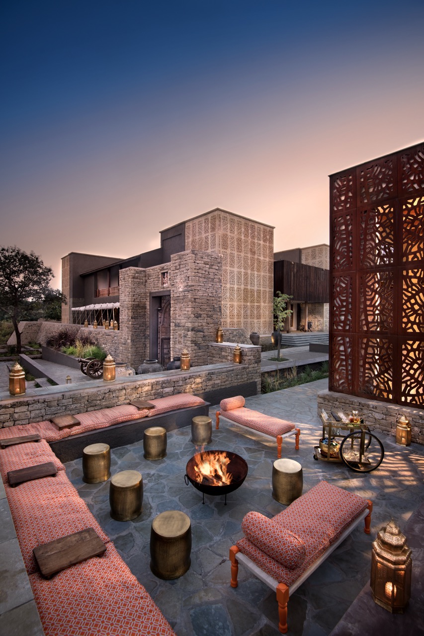 At Aramness Gir, a sunken courtyard gathers around a central firepit, with stone walls, patterned screens, and low seating shaping a space meant for slow evenings outdoors