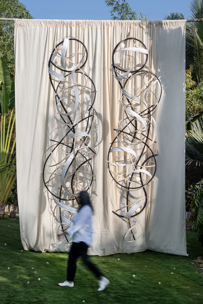 13-foot-tall sculptural lighting duo made using paper, reed and burnt bamboo